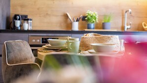 Une cuisine avec un plan de travail en bois, une machine à café et un panier en osier.