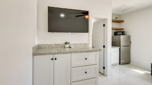 A kitchen with white cabinets, a granite countertop, a microwave, and a refrigerator. - Surf, Swim, Stay! South Padre Studio Near Beach (South Padre Island)