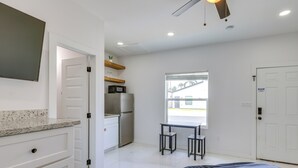 A bedroom with a bed, a desk, a refrigerator, and a window. - Easy South Padre Beach Retreat w/ Pool Access (South Padre Island)