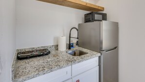 A kitchen with a granite countertop, stainless steel appliances, and wooden beams above. - Easy South Padre Beach Retreat w/ Pool Access (South Padre Island)