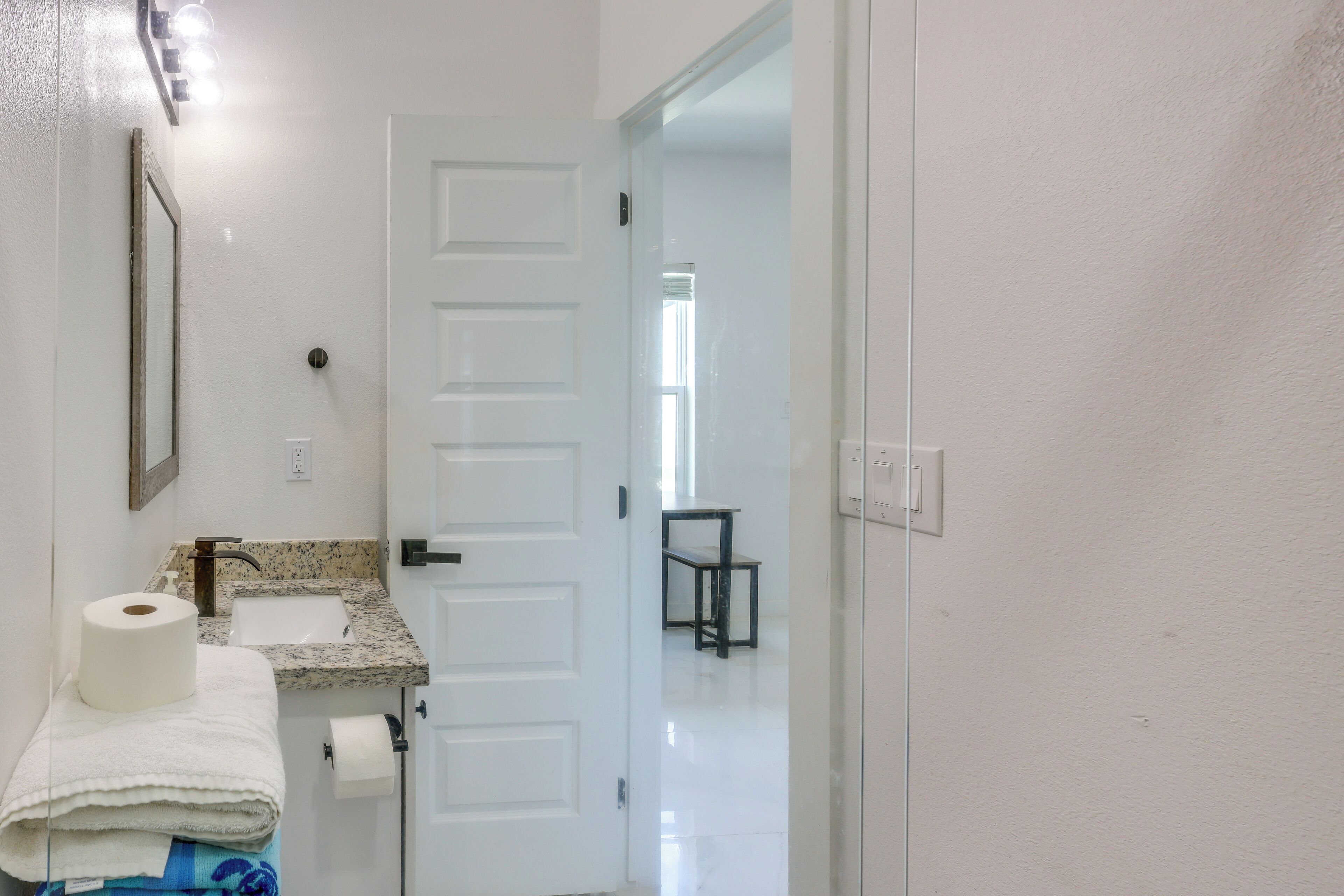 Une salle de bain avec un lavabo, un miroir et du papier toilette.