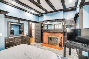 A bedroom with a bed, dresser, TV, fireplace, and a large mirror. - Walkable Schenectady Getaway: 2-unit Campus Hub (Schenectady)
