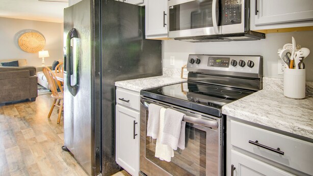 A modern kitchen with stainless steel appliances, white cabinetry, and a marble countertop. - 3 Mi to Branson Strip: 2-unit Gem w/ Pool Access! (Branson)