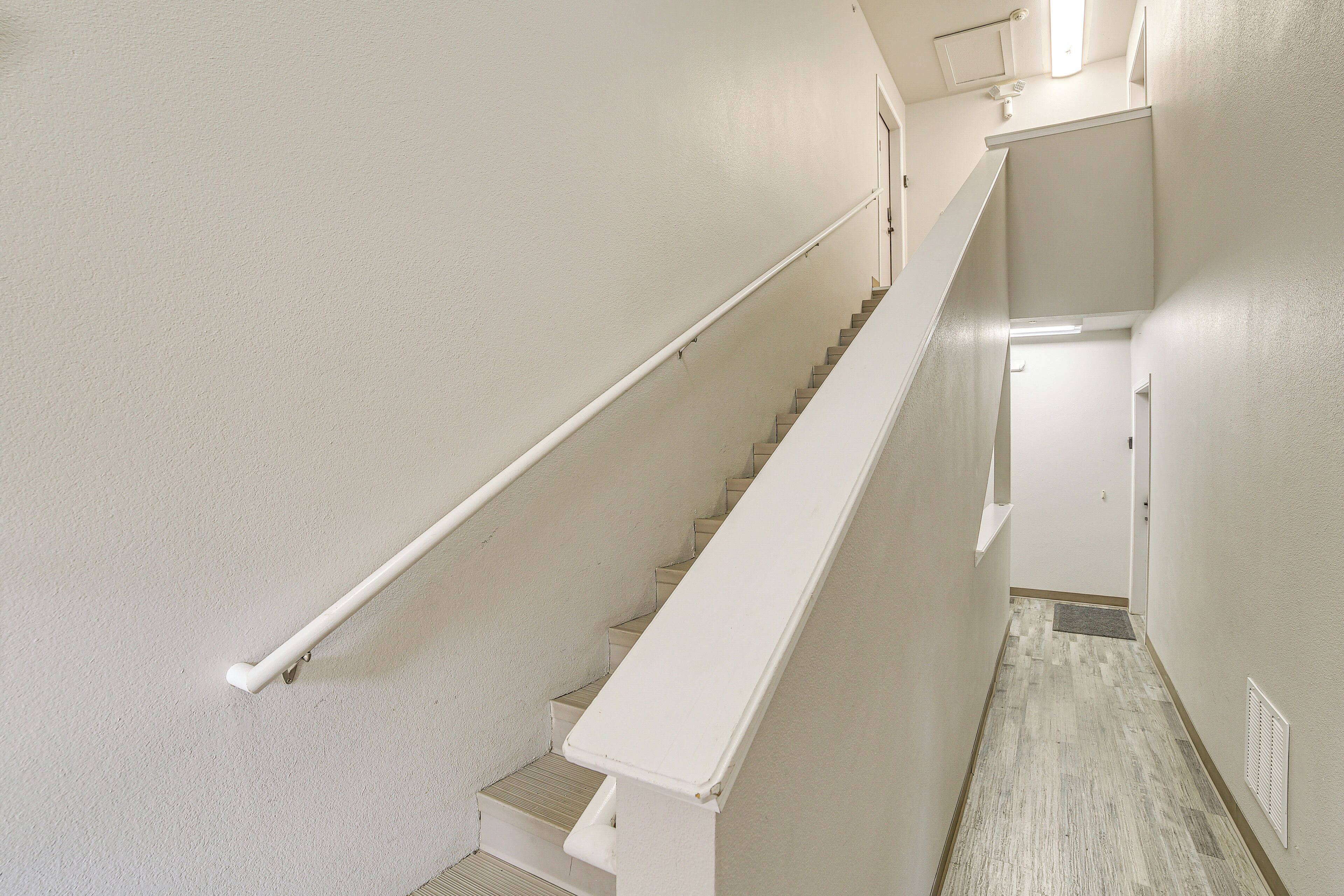 A clean, white interior with a staircase leading to a landing.