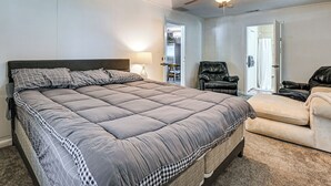 A bedroom with a large bed, a ceiling fan, a chair, and a sofa. - 2 Mi to Myrtle Beach Boardwalk: 2 King Beds! (Myrtle Beach)