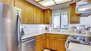 Una cocina moderna con armarios de madera, electrodomésticos de acero inoxidable y un ventanal con vistas.