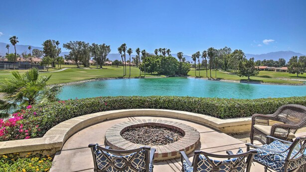 Una piscina con un hogar de fuego, mobiliario de patio y vistas a un campo de golf y montañas.