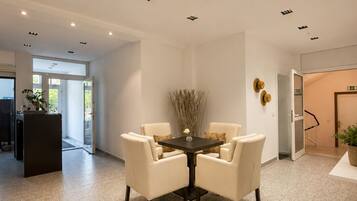 A modern interior with a round table, four chairs, and recessed ceiling lights.
