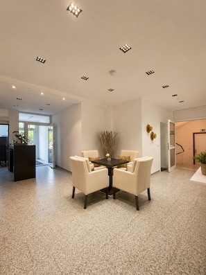 A modern interior with a round table, four chairs, and recessed ceiling lights. - Oceanview Residences Lauterbach Rügen (Putbus)