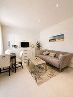 A modern living room with a sofa, coffee table, and TV.