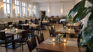 A restaurant with multiple tables, chairs, and candles.