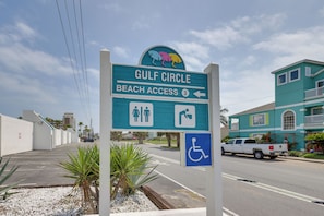 Señal direccional para el acceso a la playa Gulf Circle, con símbolos de baños y accesibilidad.