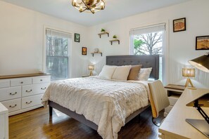 Une chambre à coucher avec un lit, des tables de chevet, un bureau et une chaise.