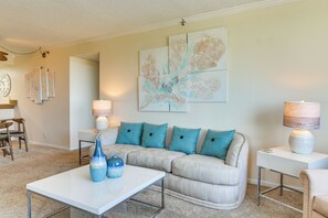 Ein Wohnzimmer mit einer Couch, zwei Beistelltischen, einem Couchtisch und Wandbildern.
