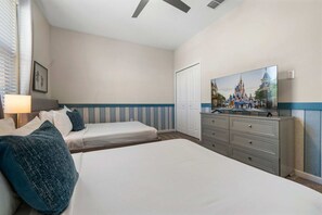 Une chambre d’hôtel avec deux lits, une commode, un téléviseur et une porte.
