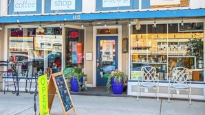 A storefront with signs for coffee, shop, and bar. - Charming Bungalow Walkable to Main St | King Suite, Yard, Workspace (Elgin)