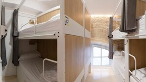Camera con letto a castello, parete in legno e finestra.