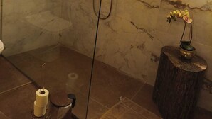 A modern bathroom with a glass-enclosed shower, marble walls, and a wooden stool with a vase. - Wonderful Maltese Character 1-bedroom with AC in charming Ħal Tarxien (Ħal Tarxien)