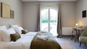 A bedroom with a bed, a desk, and a chair.