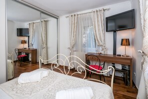 A hotel room with a bed, a desk, a chair, a TV, and a mirror. - Adorable 1BDR apt with AC&WiFi in strict center of Split - Xenia (Split)