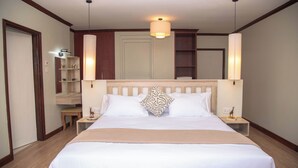 A hotel room with a large bed, bedside tables, a mirror, and a wooden headboard. - Mt. Kenya View Villa 5BR Ensuite Guest Wing (Nyeri)