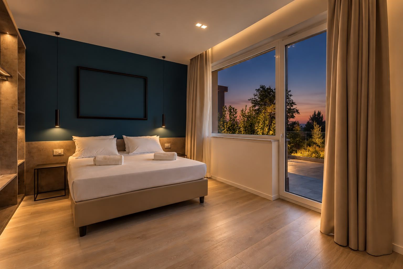 A modern bedroom with a large bed, bedside tables, a framed picture on the wall, and a view of the outdoors through a sliding glass door.
