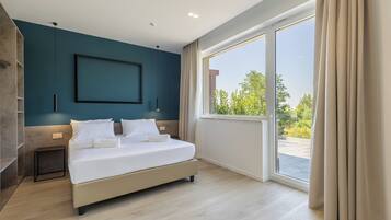 Ein modernes Schlafzimmer mit einem großen Bett, Blick ins Grüne und einem minimalistischen Design.