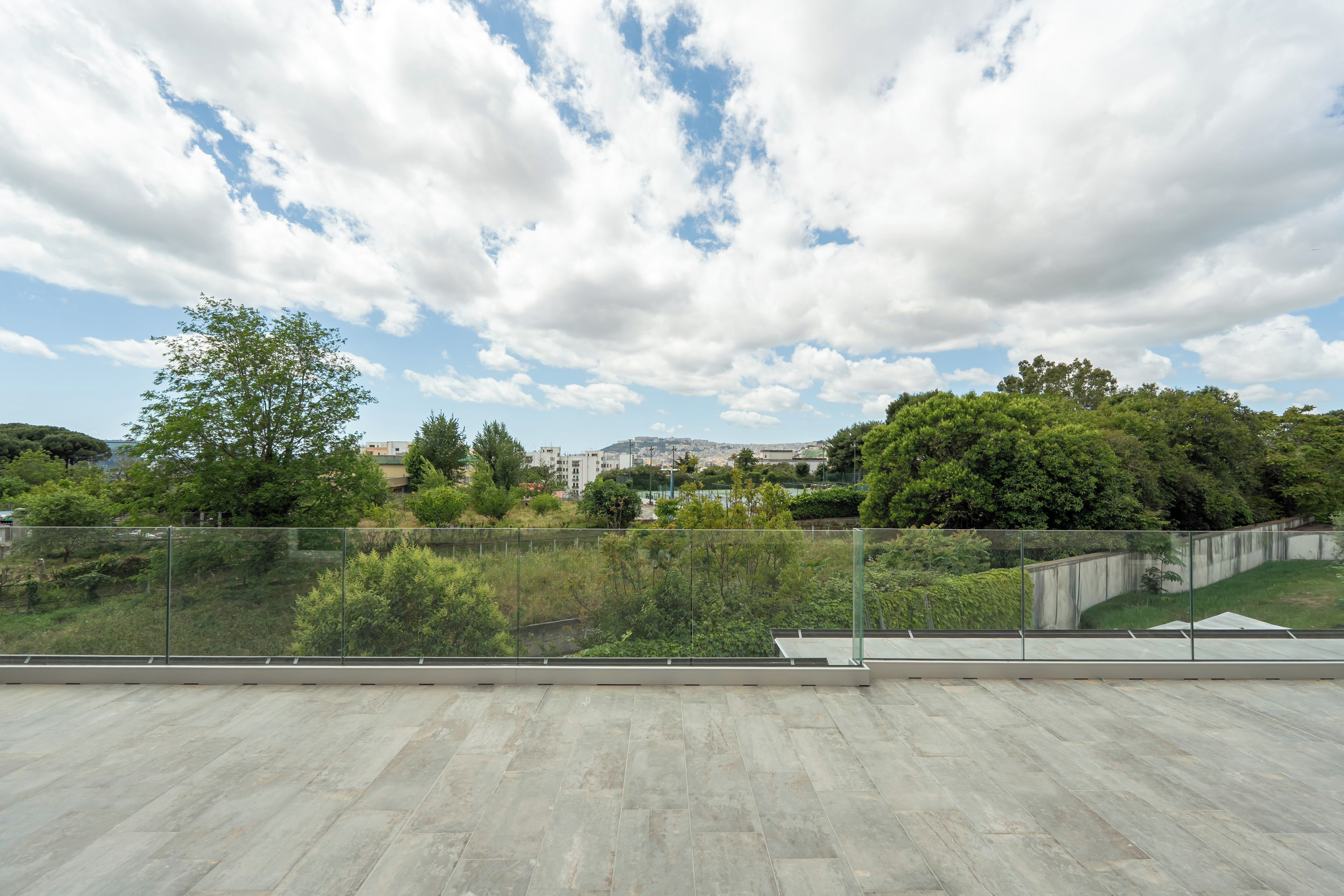 Une vaste terrasse offrant une vue sur le paysage urbain et la verdure.