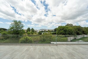 Une vaste terrasse offrant une vue sur le paysage urbain et la verdure.