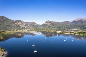 Ein See mit Booten, umgeben von Bergen und einer Stadt.