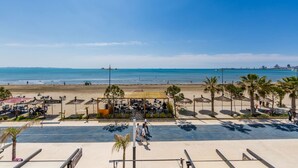 A beachside view with a café, palm trees, and a clear sky. - Sun Sea Apartment Durr s Waterfront (Durrës)