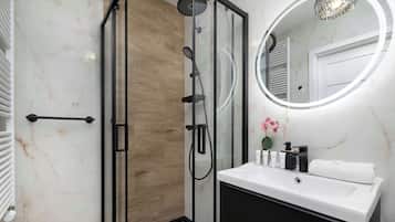 Chuveiro, secador de cabelo, toalhas de banho, shampoo