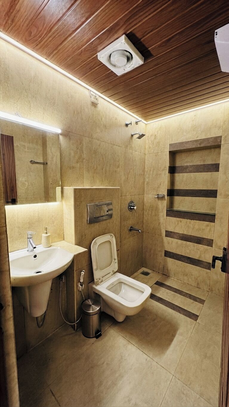 A compact bathroom with a sink, toilet, and shower area.