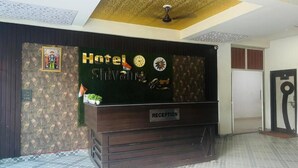 Un mostrador de recepción con un letrero que dice 'Hotel Shivani'.