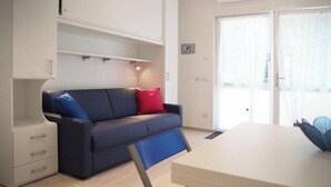 Una sala moderna con sofá, mesa de comedor y armario empotrado.