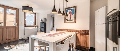 Una cocina moderna con comedor, detalles de madera y vistas a la montaña.