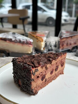 A slice of chocolate cake with a crumbly topping on a plate.
