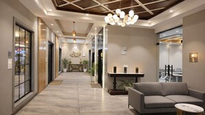 Un moderno vestíbulo de hotel con recepción, zona de estar y una sala de conferencias.