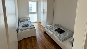 Ein Schlafzimmer mit einem Hochbett, einem Kleiderschrank und einem Fenster.