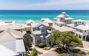 A coastal residential area with houses featuring gabled roofs and a view of the ocean. - Sophisticated 5 BR, Bikes, & Private Beach Access + Under New Management (Santa Rosa Beach)