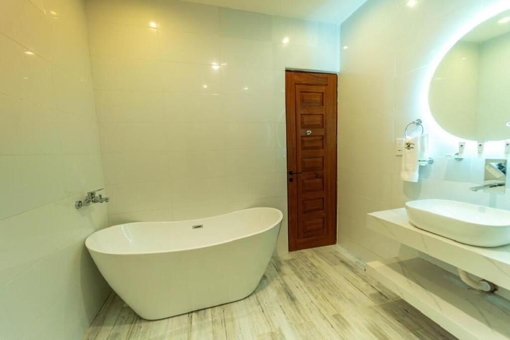 A modern bathroom with a freestanding bathtub, a sink, and a mirror.