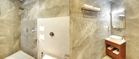 A bathroom with a marble wall, a wooden vanity, a toilet, and a shower area.
