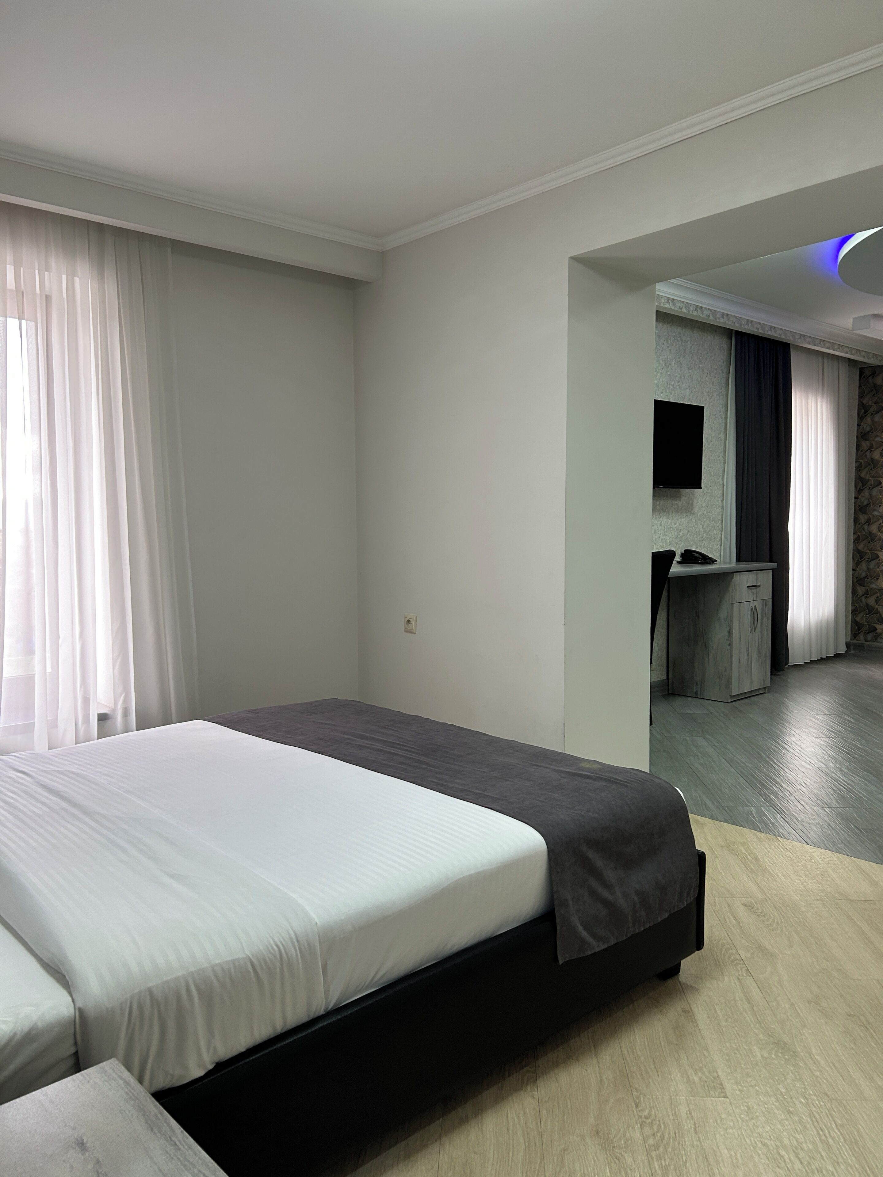 Une chambre d’hôtel moderne équipée d’un lit, d’un bureau et d’une télévision.