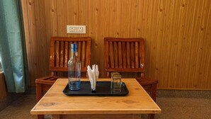 Et træbord med en bakke, en flaske og et glas.