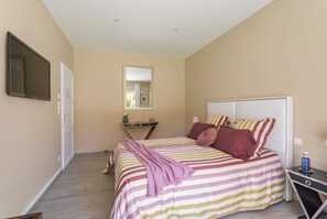A bedroom with a bed, bedside table, and a mirror on the wall. - Bed and Breakfast 'Suite Madeloc' with Mountain View, Wi-Fi and Air Conditioning (Sorède)