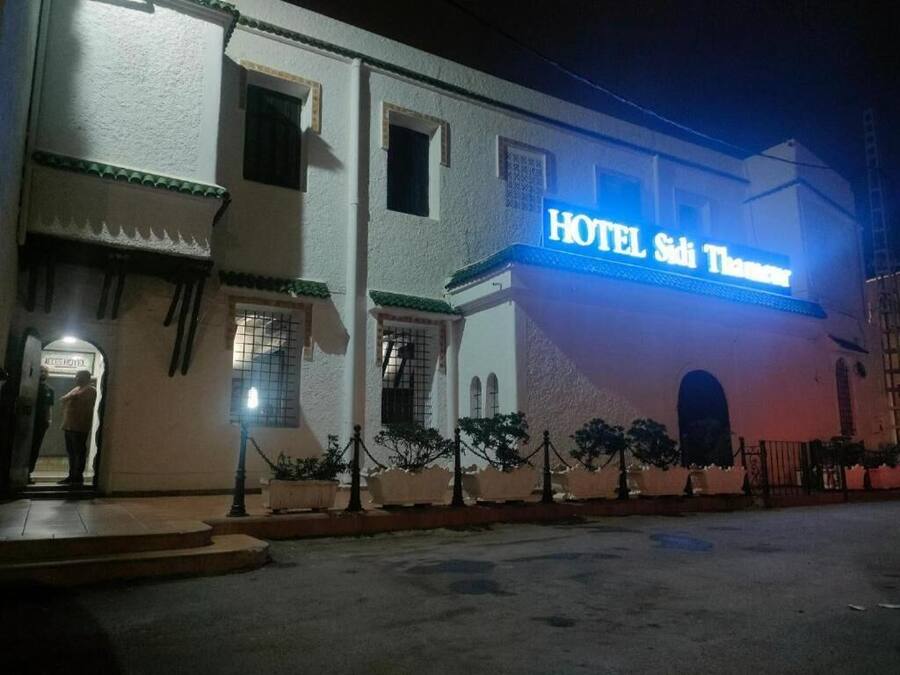 Een gebouw met een bord waarop 'HOTEL Sidi Thamiam' staat.