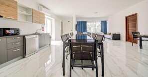 Een moderne keuken met een eethoek, een grote tafel en uitzicht op de stad.