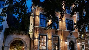 Un edificio de ladrillo con ventanas grandes y una entrada en arco.