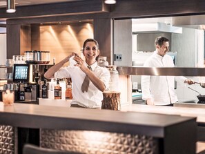 Eine Bar mit Theke, Flaschen und einer Kaffeemaschine.