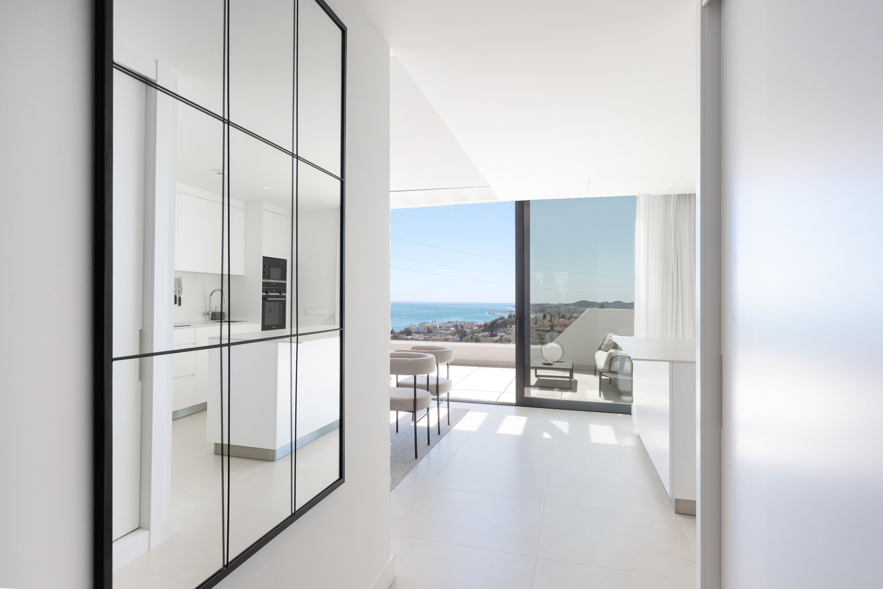 Ein modernes Interieur mit Küche, Essbereich und Balkon mit Stadtblick.